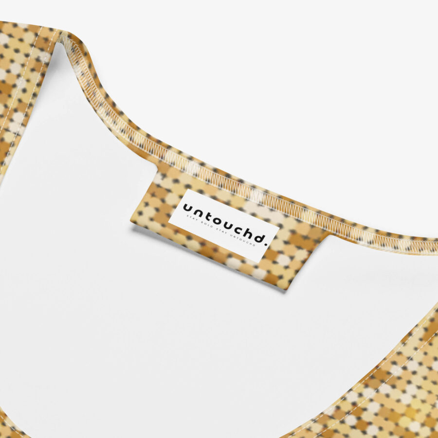 Close-up of the interior neckline of the Golden Dust Mesh Bodycon Dress, showing the Untouchd brand label stitched onto the golden patterned fabric lining.
