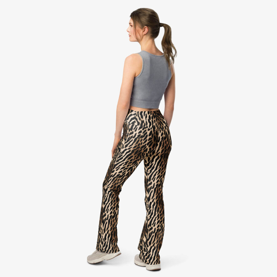 Woman wearing Wild Charm Leopard Flare Leggings viewed from the back, paired with a gray sleeveless crop top and sneakers.