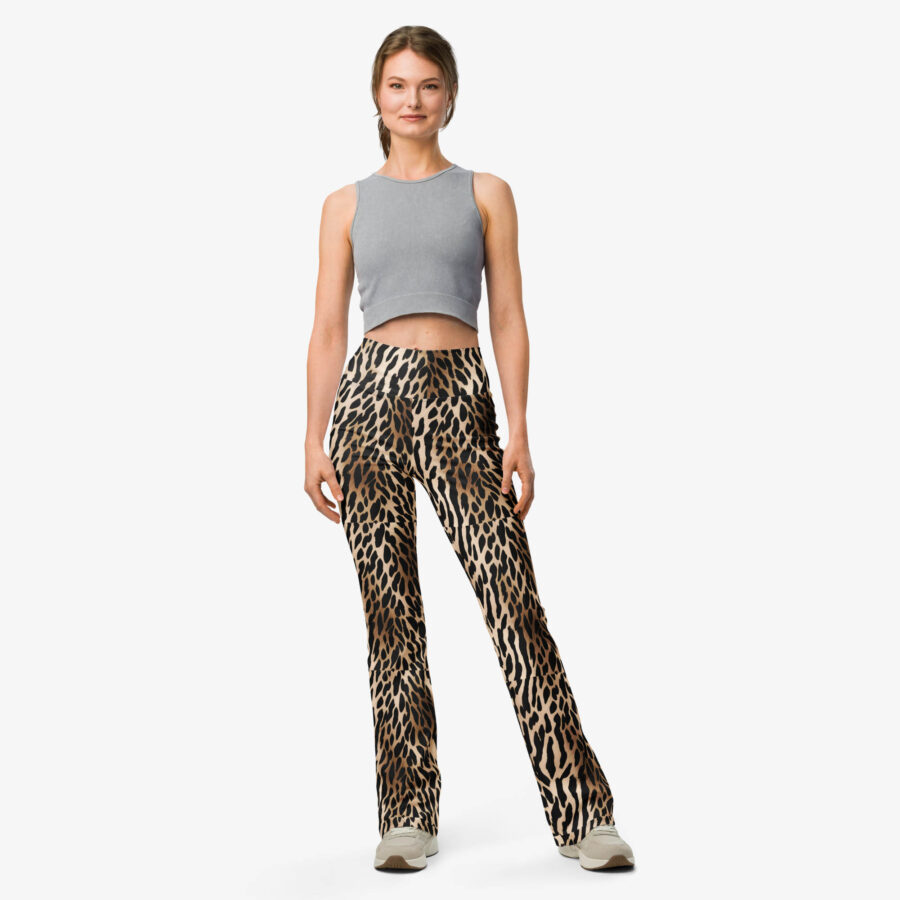 Model standing front-facing in Wild Charm Leopard Flare Leggings with a gray crop top and beige sneakers, against a white background.
