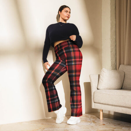 Stylish indoor scene featuring a woman leaning against a wall in Ash Red Check Flare Leggings and a black cropped sweater.