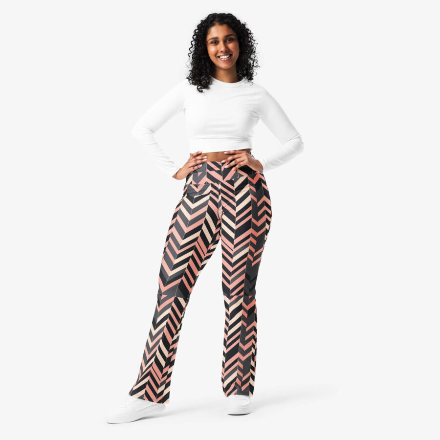 Smiling model showcasing blush stripe flare leggings with hands on hips, styled with a long-sleeve white crop top and white sneakers.