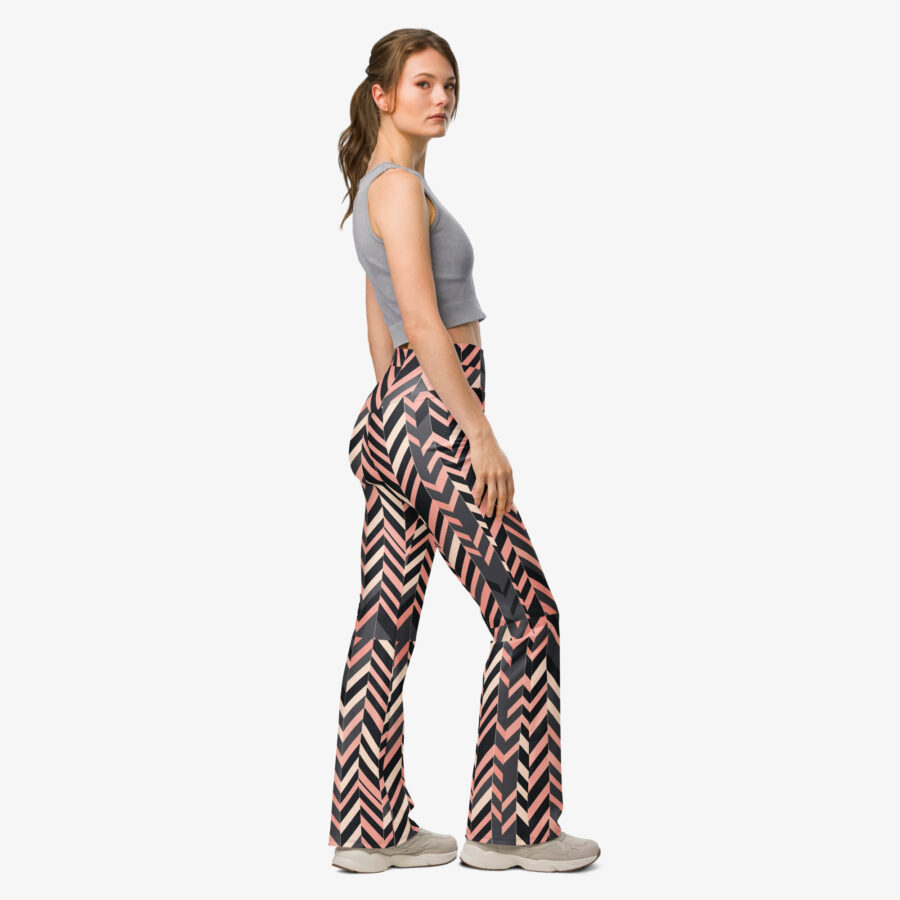 Side profile of a woman in blush stripe flare leggings, highlighting the flared cut and geometric blush-toned print, paired with a grey crop top and neutral sneakers.