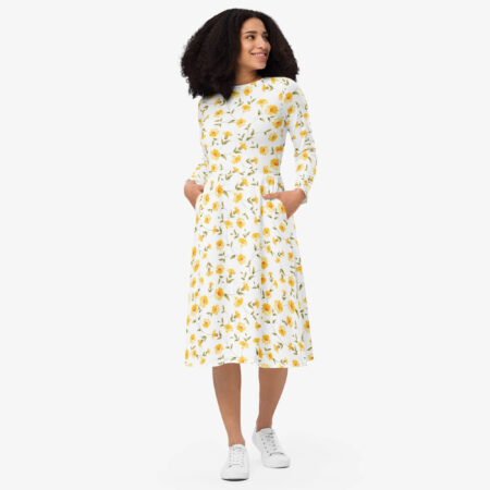 Woman wearing the Sunbeam Bloom Midi Dress with yellow floral print and white sneakers, smiling and looking to the side.