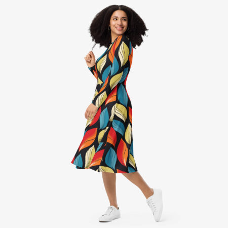 Side view of a woman walking in the Harvest Drift Midi Dress, highlighting the flowing midi cut and colorful leaf motif against a dark base.