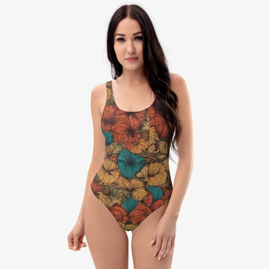 Model wearing the Amber Tropic Bloom Swimsuit against a white background, showcasing the vivid tropical floral pattern in amber, teal, and burnt orange.