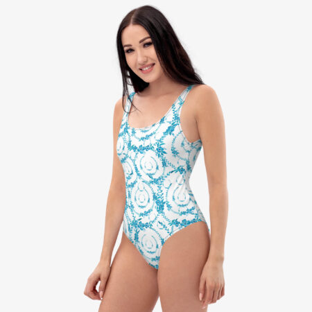 Alt Text: Model smiling in the Azure Bloom One-Piece Swimsuit, showing the symmetrical blue floral print and soft scoop neckline.