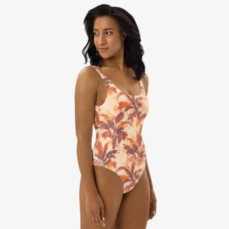 Three-quarter view of a woman modeling the Rustic Autumn Palm One Piece Swimsuit, showing the curve-hugging silhouette and bold orange-brown tropical design.