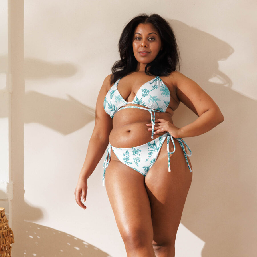 A woman standing confidently in the Botanical Harmony String Bikini, facing forward with natural sunlight casting soft shadows.