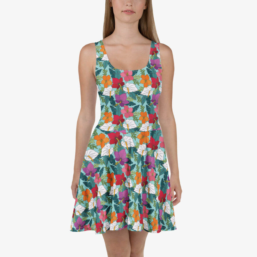 Front view of a model in a floral skater dress with a fitted bodice and flared skirt, featuring multicolored tropical blooms and white leaves.