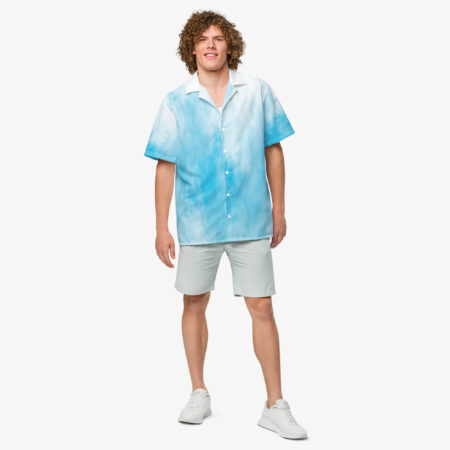 Man facing forward wearing a light blue and white cloud-print button shirt with short sleeves, styled with light shorts and white sneakers.